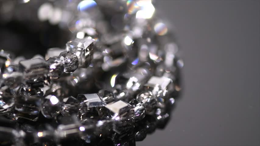 Diamonds crystals bracelet or necklace over black background, beautiful gems, brilliants sparkling with colorful caustics, rainbow lights. Moissanite. Zirconia.