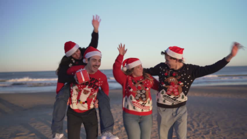 Happy friends celebrating Christmas on the beach