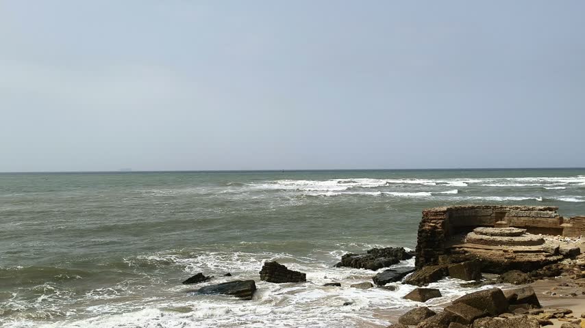 Powerful Sea Waves Rolling Toward a Rocky Coast, Foamy Water Washing Along Shoreline with Large Concrete Breakwater Blocks – 4K Footage