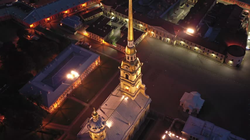Aerial view of the illuminated Peter and Paul Fortress with its iconic golden spire and historic stone walls at night in Saint Petersburg, Saint Petersburg, RUSSIA.