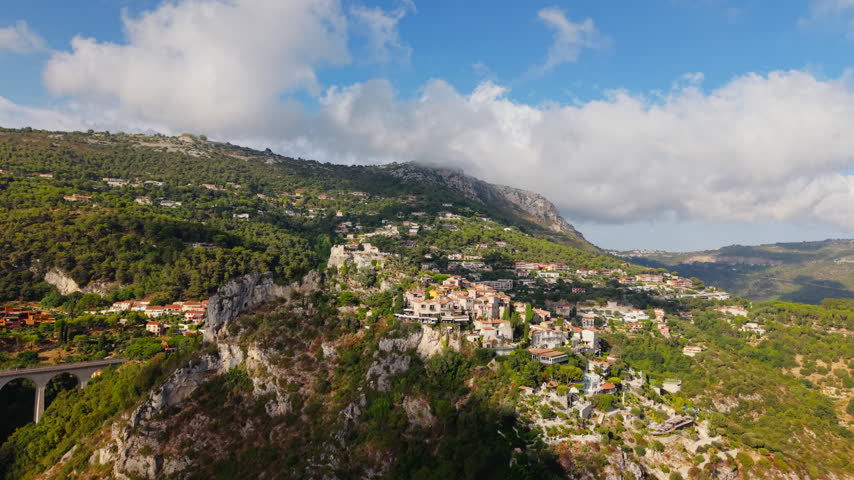 Drone view of hilltop Eze Village with stone buildings and lush landscape below