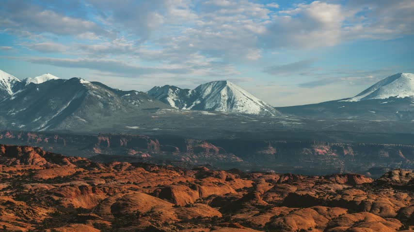 Time lapse of Arches National Park with red rock formations and snow capped La Sal Mountains. Utah, USA