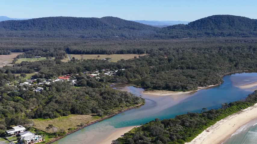 High-angle drone shot of Killick Creek meeting the ocean at Crescent Head, New South Wales.