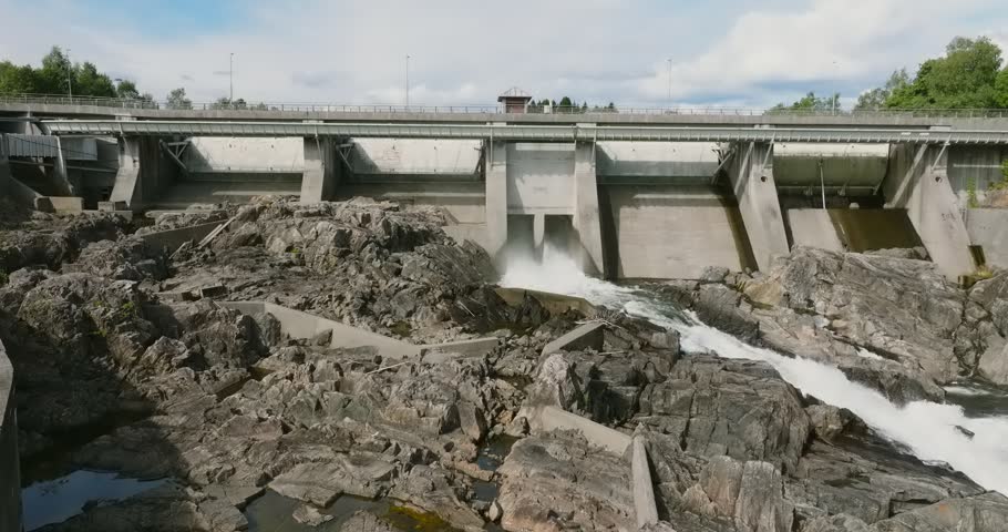 Hydroelectric dam at Rykene with water flow and rocky landscape in slow motion