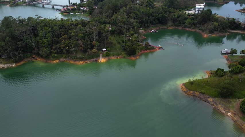 Cinematic Drone Flight Over Peaceful Lakeside Landscape in Guatape Colombia