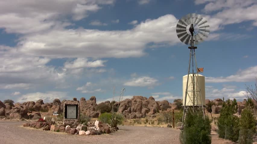 HD wide view of the "City of Rocks" State Park in New Mexico, with a vintage "Aermotor" windmill turning on the right side