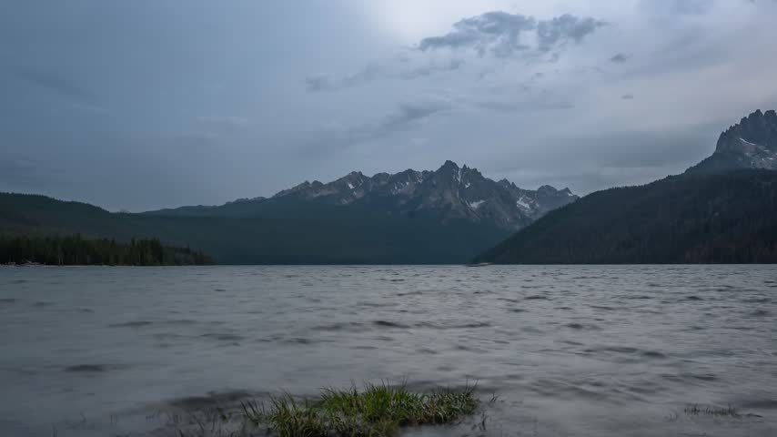 View of Redfish Lake and Sawtooth Mountains under a cloudy sky in Stanley, Idaho, United States.