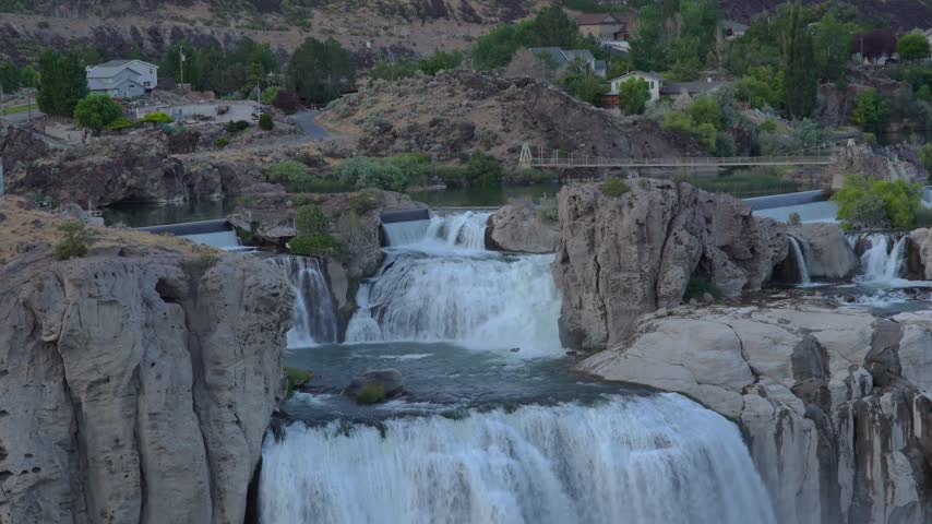 View of the cascading Shoshone Falls surrounded by rugged rocky cliffs and lush greenery in Twin Falls County, Idaho, United States.