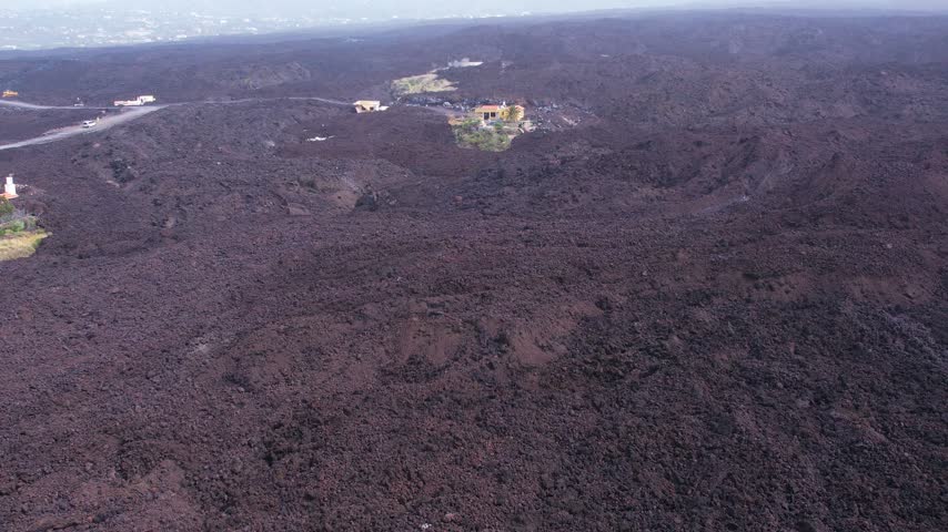 Aerial lava of Cumbre Vieja volcano two years after eruption with houses of small town on La Palma island Canary Islands Spain