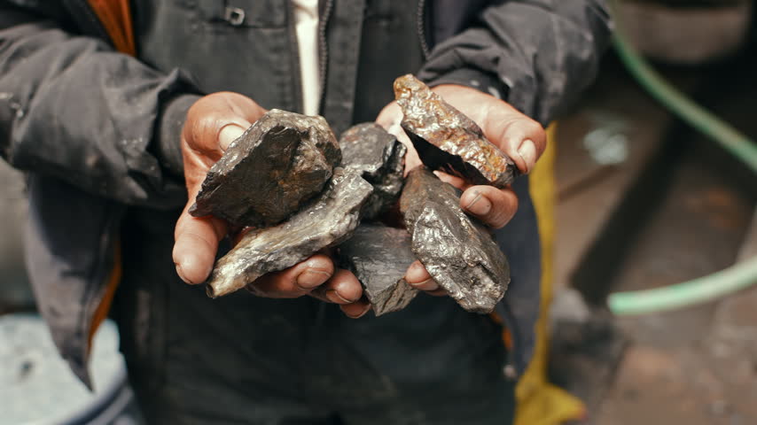 Worker Holding Gold Ore Before Processing