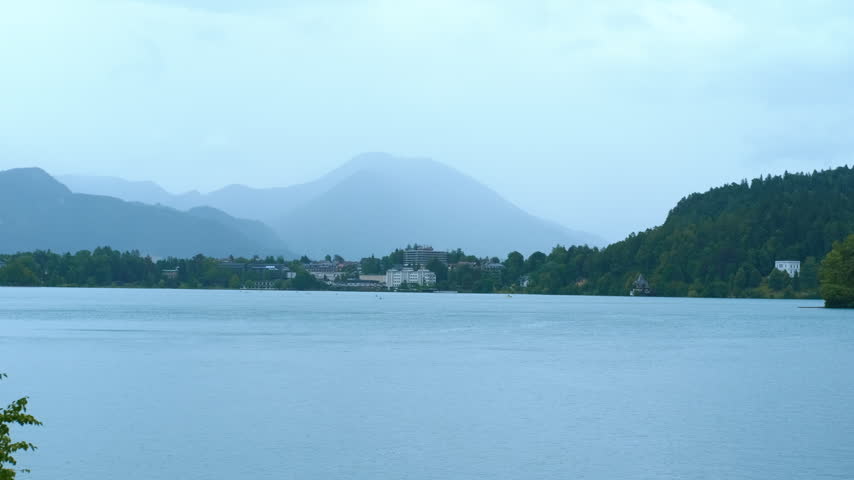 Bled island emerging from lake bled, slovenia. Lake bled and bled island with its assumption of mary pilgrimage church appearing from behind a hill