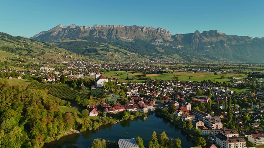 Aerial view of eastern Switzerland, with Schloss Werdenberg above Werdenbergersee, medieval timber homes, vineyards and the dramatic Churfirsten range.