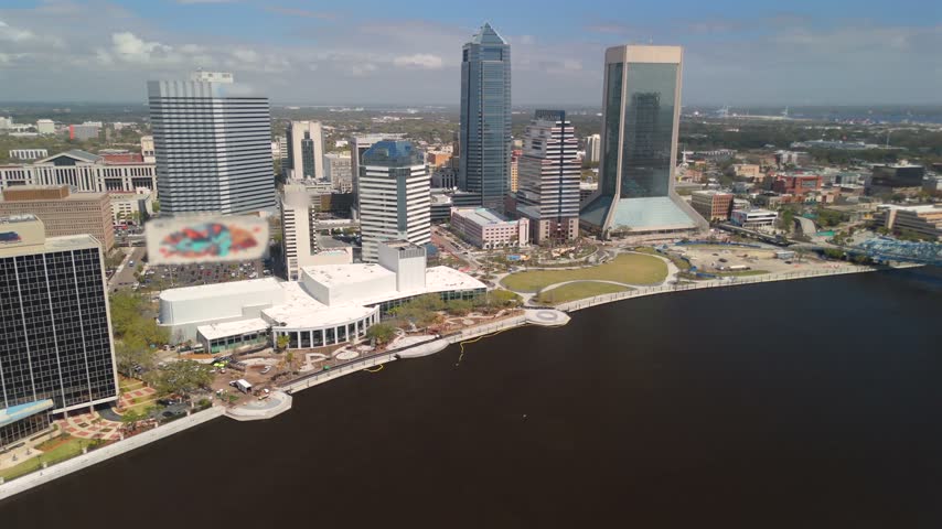 Drone view of downtown Jacksonville, Florida, showing modern skyscrapers, riverfront parks and Riverwalk along the St. Johns River