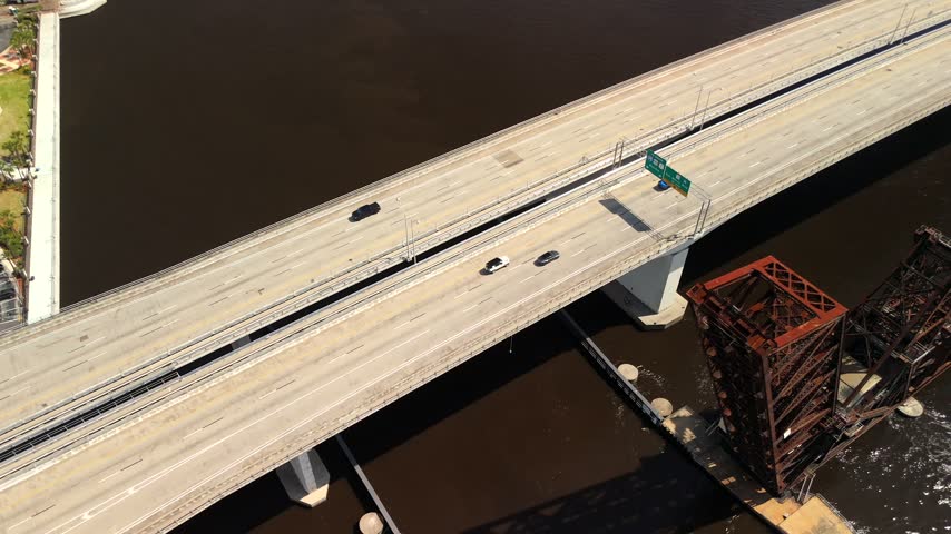 Drone view of highway traffic and railroad drawbridges crossing the St. Johns River in Jacksonville, Florida