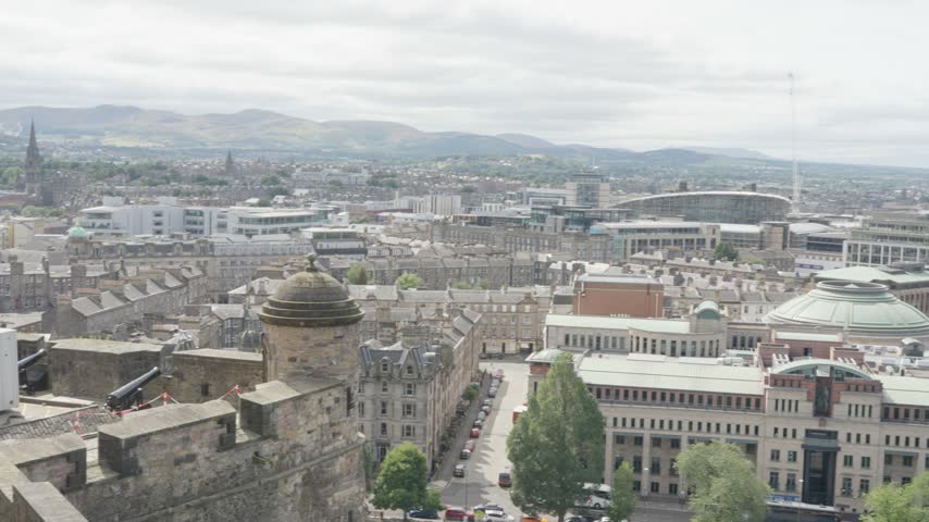Slow pan right across Edinburgh city centre seen from castle ramparts