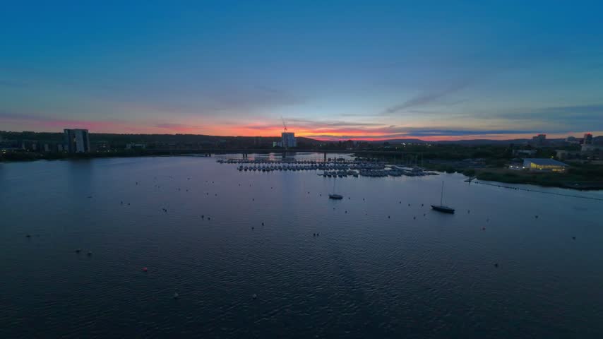 Aerial drone footage of Cardiff Bay Yacht Club and the Cardiff Bay Link Road bridge at the mouth of the River Taff at sunset