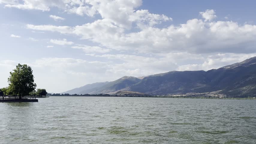 Distant scenic view across Lake Pamvotida toward the mountains and Perama in Greece. from a distance.