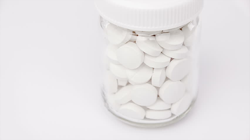 Medical pills placed on rotating table, shot with white seamless background