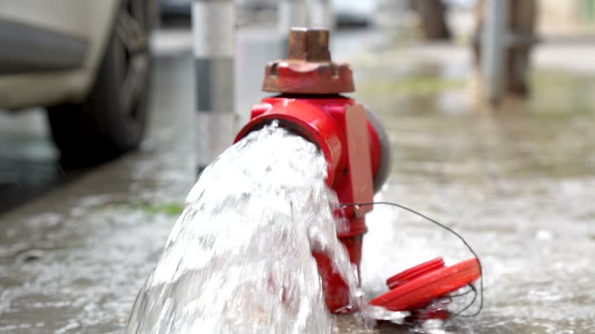 Fire hydrant releasing water on urban street