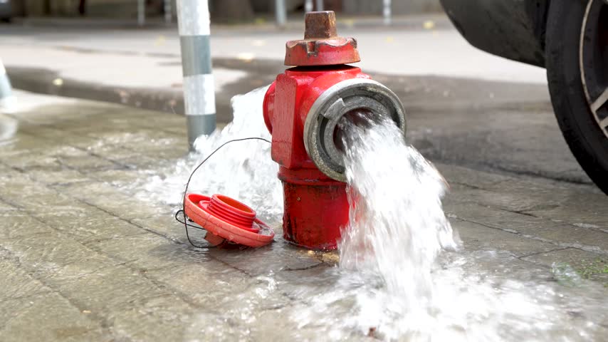 Fire hydrant releasing water on urban street