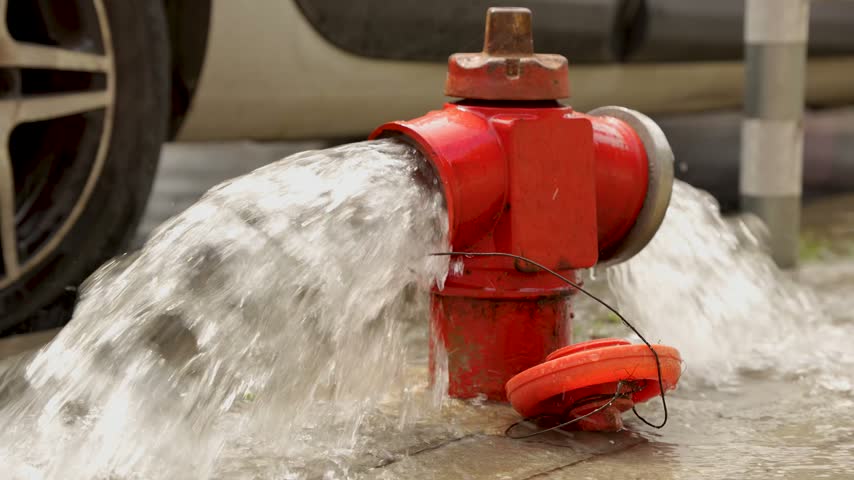 Fire hydrant releasing water on urban street