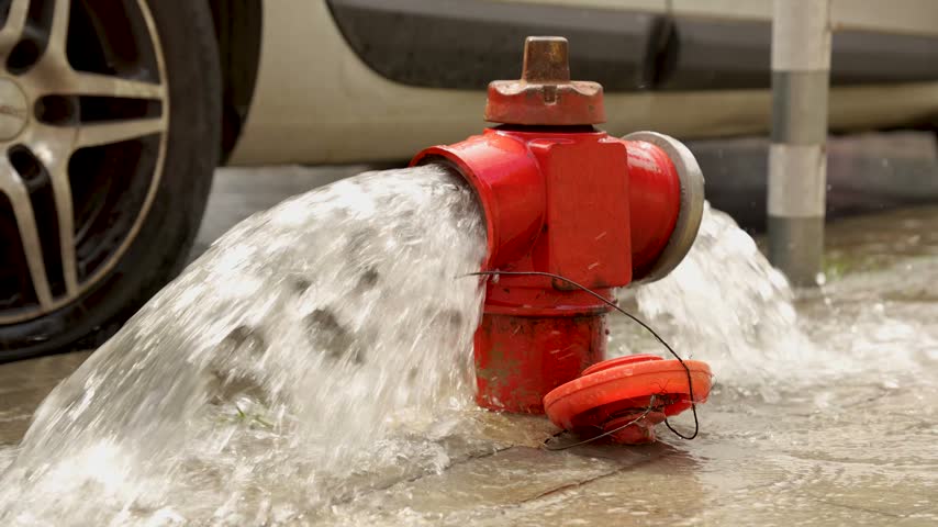 Fire hydrant releasing water on urban street