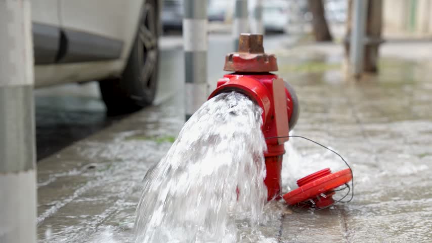 Fire hydrant releasing water on urban street