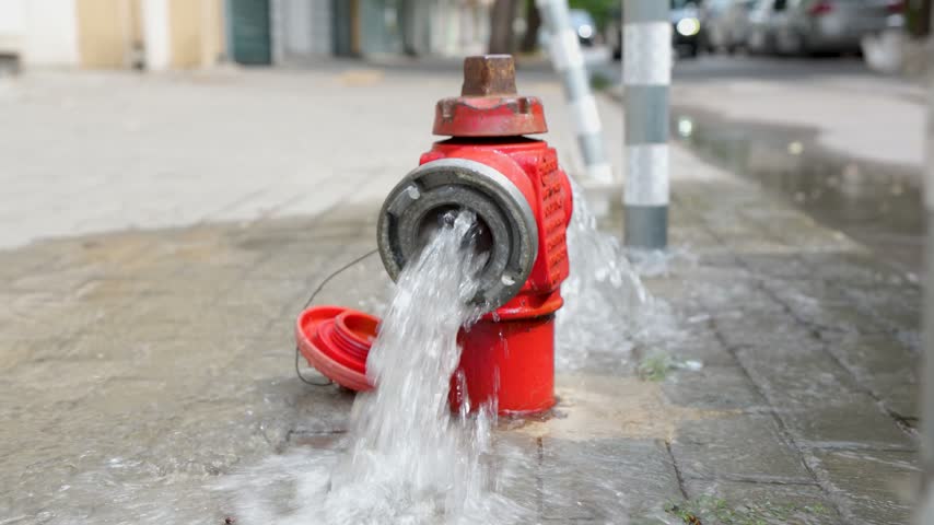 Fire hydrant releasing water on urban street
