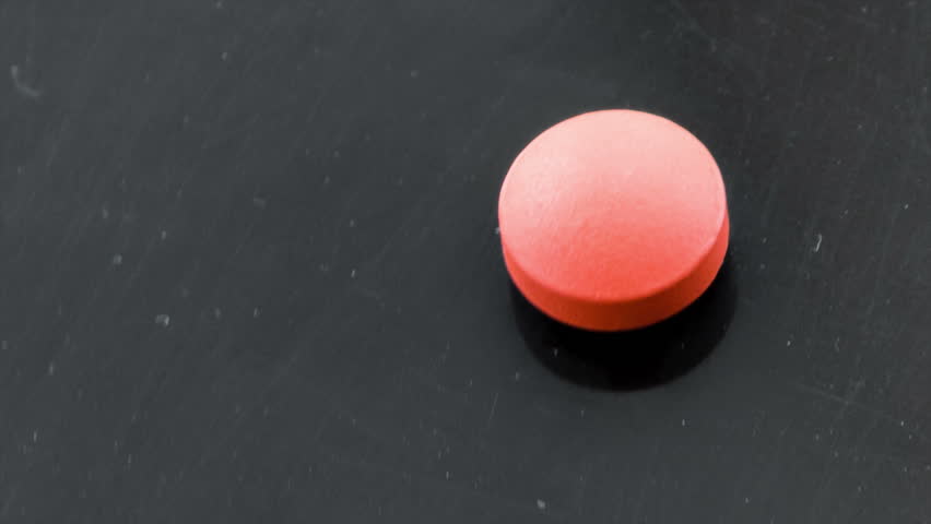 Medical pills placed on rotating table, shot with black background