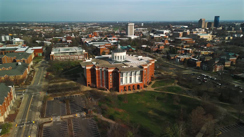 Aerial drone view of William T. Young Library, University of Kentucky campus, and downtown Lexington skyline beyond the landscaped grounds
