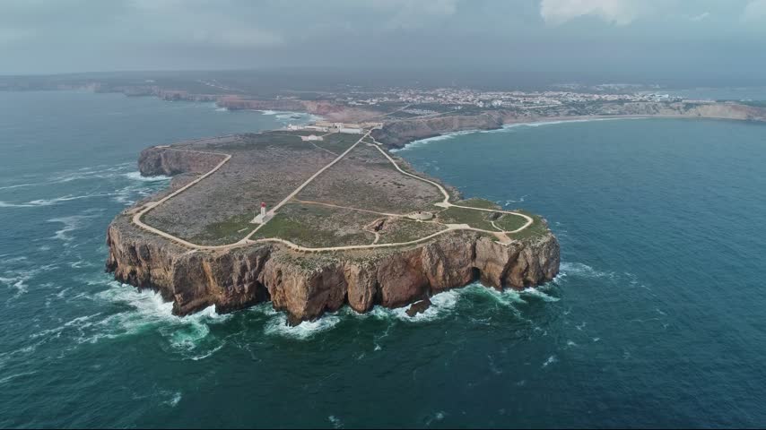 Aerial view of the dramatic cliffs and lighthouse at Sagres Point overlooking the Atlantic Ocean in Portugal.