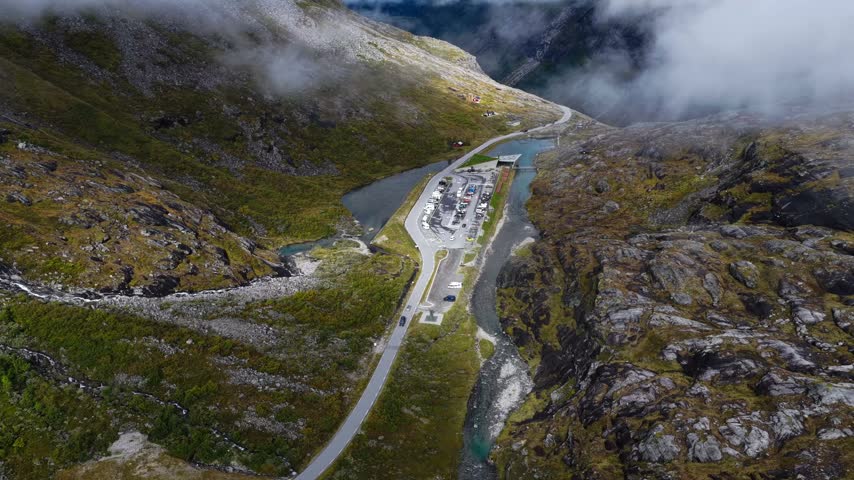 Aerial view of the winding Trollstigen mountain road with its parking area and surrounding rocky cliffs in Andalsnes, More og Romsdal, Norway.