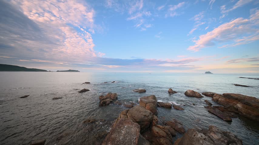 Scenic coastal landscape view at sunset featuring rocky shoreline and peaceful ocean waters in Jinshan, New Taipei, Taiwan.
