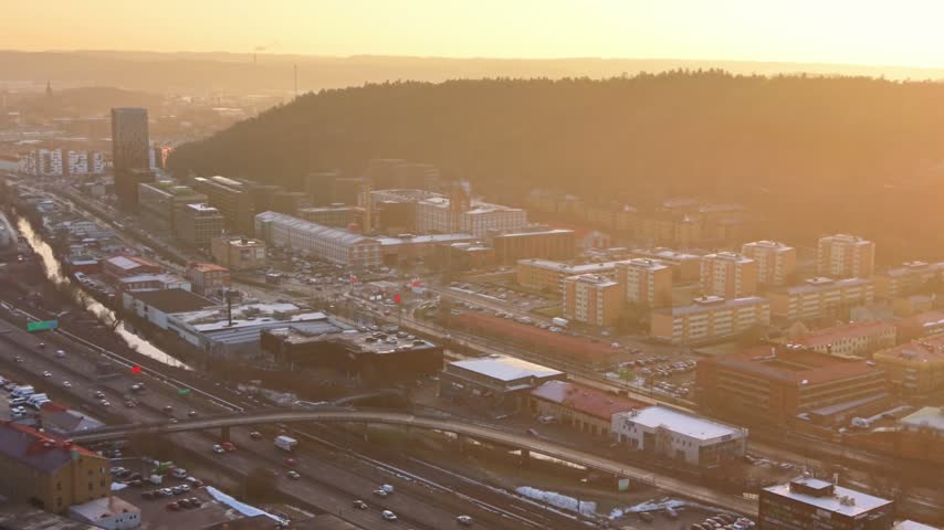 Aerial view of Kalleback residential area and Molndal city with urban buildings and roads at sunset in Gothenburg, Vastra Gotaland County, Sweden.