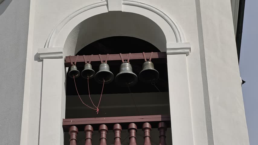 A clock tower with bells hanging from its sides, suitable for backgrounds or architectural scenes.