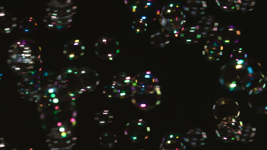Flight of Many Soap Bubbles. A large number of soap bubbles moving in one direction against a black background. Great for use in blending