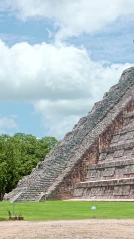 Majestic Mayan pyramid of Chichen Itza, also known as El Castillo or Temple of Kukulcan, standing against a blue sky with clouds in the archaeological site located in Yucatan, Mexico