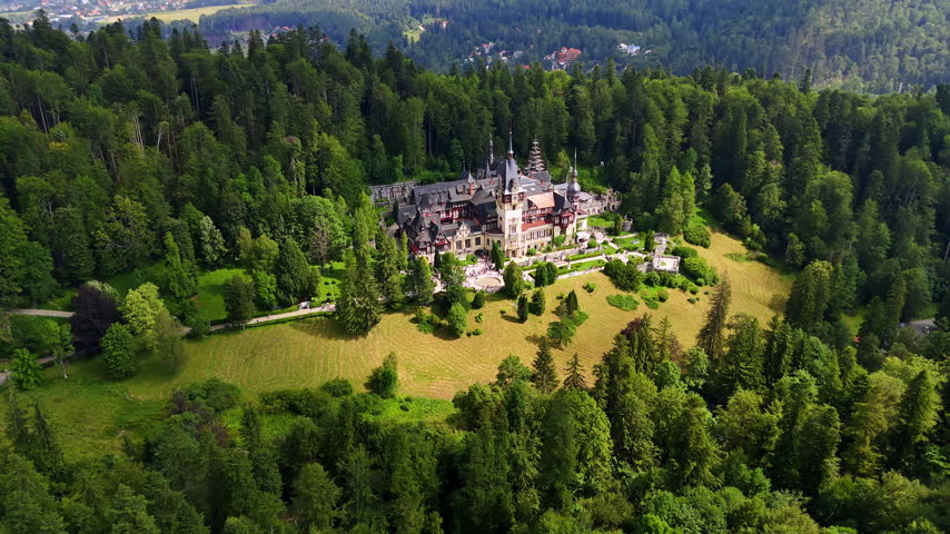 Striking scenery of the Peles Castle in the Carpathian Mountains, Romania. Lots of tourists stand in the line waiting for their turn to enter the landmark. Aerial view.