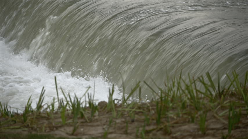 Close-up of water cascading over a small waterfall with foam