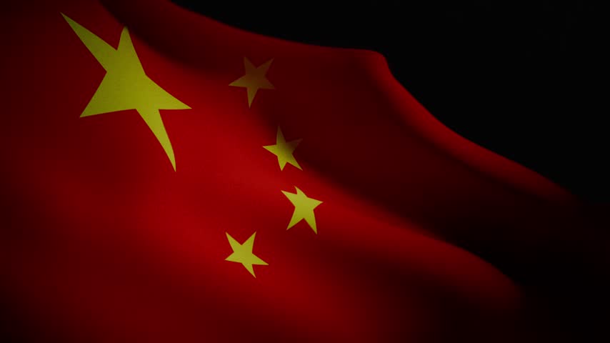 A detailed slow motion video of the Chinese flag waving against a dark background, illuminated by a dramatic spotlight, showcasing red fabric, golden stars, and national symbol.