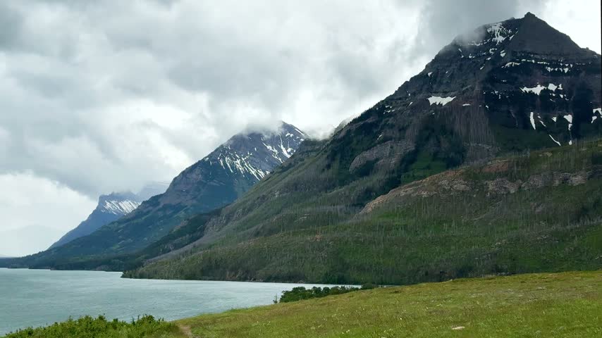 Waterton Lakes National Park. The mountains rise in the background under a cloudy sky.