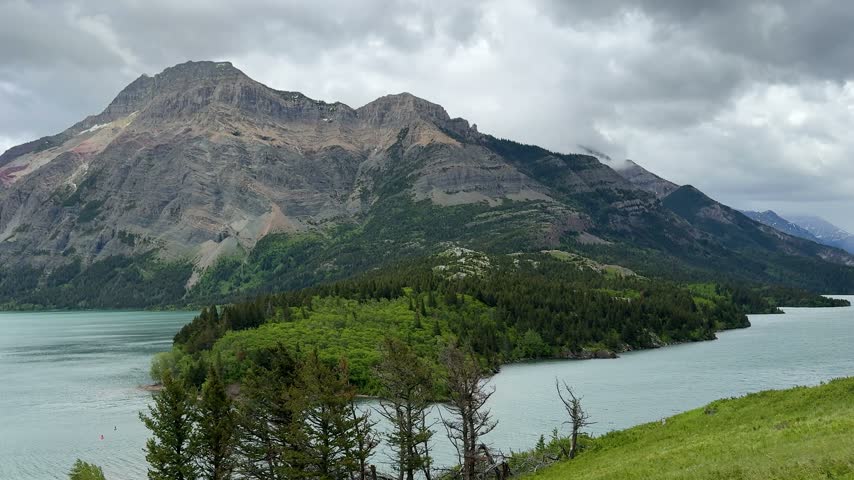 Waterton Lakes National Park. The mountains rise in the background under a cloudy sky.