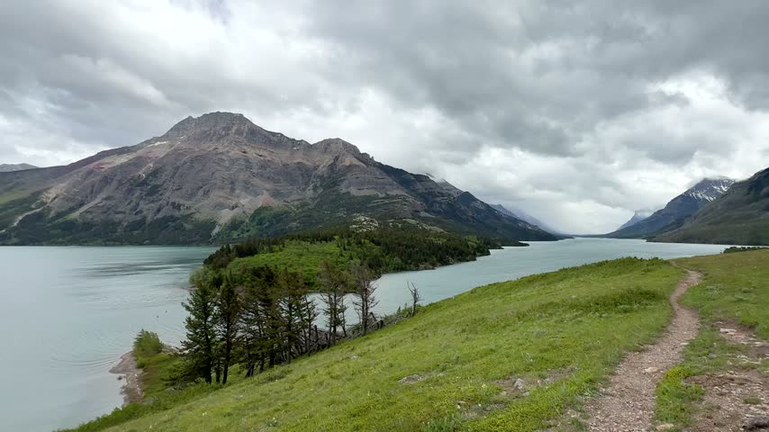 Waterton Lakes National Park. The mountains rise in the background under a cloudy sky.