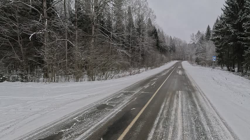 Winter road with snow, highway with cars on a sunny winter day. Winter landscape, road and shoulder covered with snow.