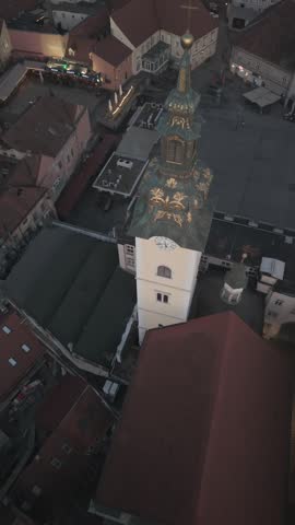 Aerial view of Zagreb Cathedral and the historic city center in Croatia. Cinematic drone shot of the gothic church towers, red rooftops, and urban skyline during daylight.