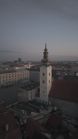 Aerial view of Zagreb Cathedral and the historic city center in Croatia. Cinematic drone shot of the gothic church towers, red rooftops, and urban skyline during daylight.