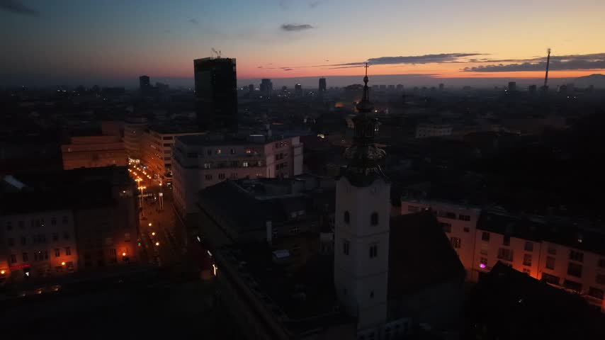 Aerial view of Zagreb Cathedral and the historic city center in Croatia. Cinematic drone shot of the gothic church towers, red rooftops, and urban skyline during daylight.