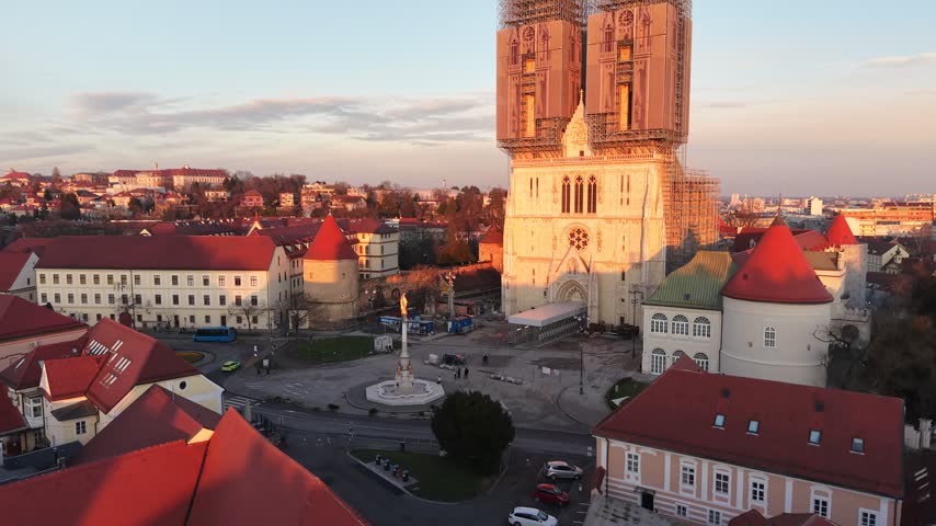 Aerial view of Zagreb Cathedral and the historic city center in Croatia. Cinematic drone shot of the gothic church towers, red rooftops, and urban skyline during daylight.