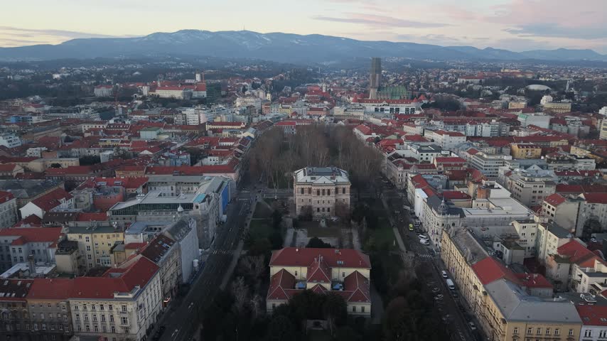 Aerial view of Zagreb Cathedral and the historic city center in Croatia. Cinematic drone shot of the gothic church towers, red rooftops, and urban skyline during daylight.