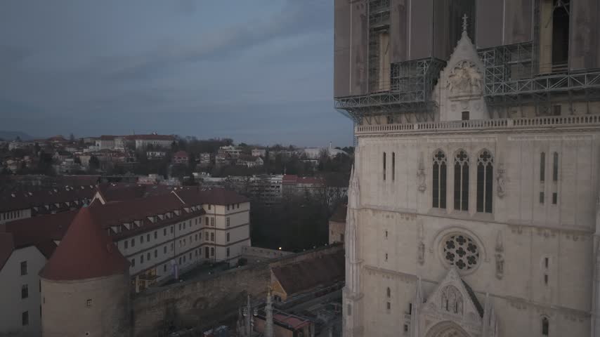 Aerial view of Zagreb Cathedral and the historic city center in Croatia. Cinematic drone shot of the gothic church towers, red rooftops, and urban skyline during daylight.